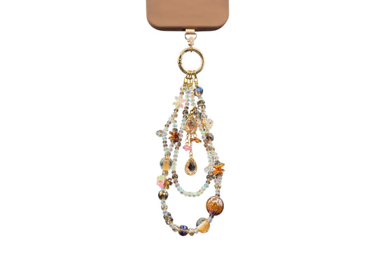 Bracelet Ambre Bloomeliya tons ambre, caramel et ivoire, complet porté sur un téléphone