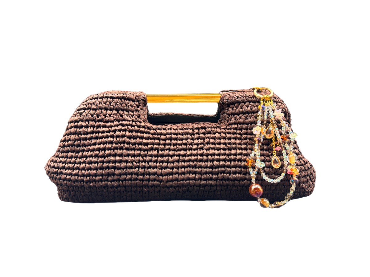 Bracelet Ambre Bloomeliya tons ambre, caramel et ivoire, accroché à un sac à main