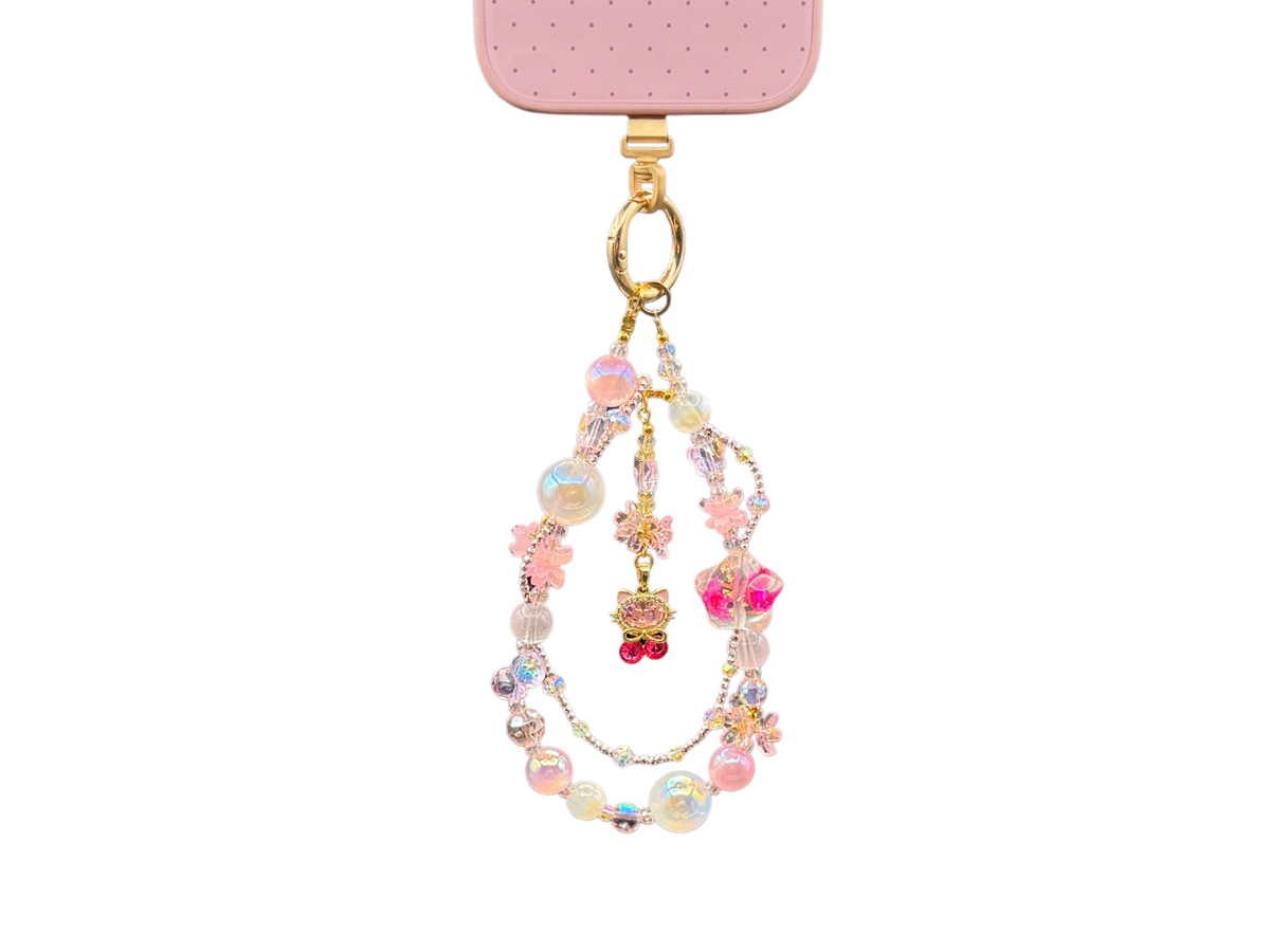 Bracelet Chérie Bloomeliya rose bonbon et perles irisées, complet porté sur un téléphone